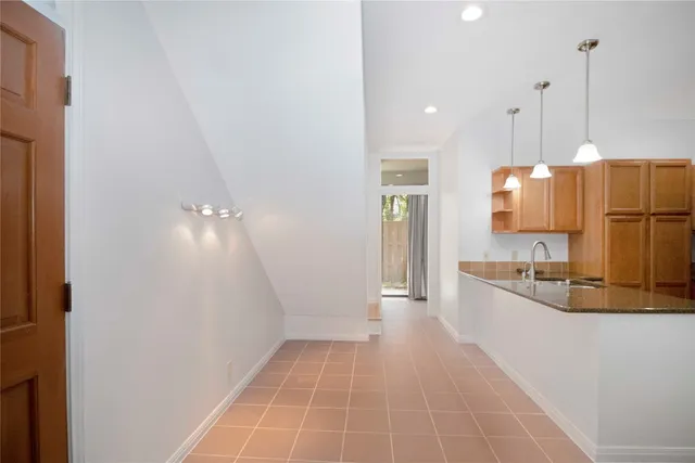 a view of a kitchen with kitchen island a sink stainless steel appliances and cabinets