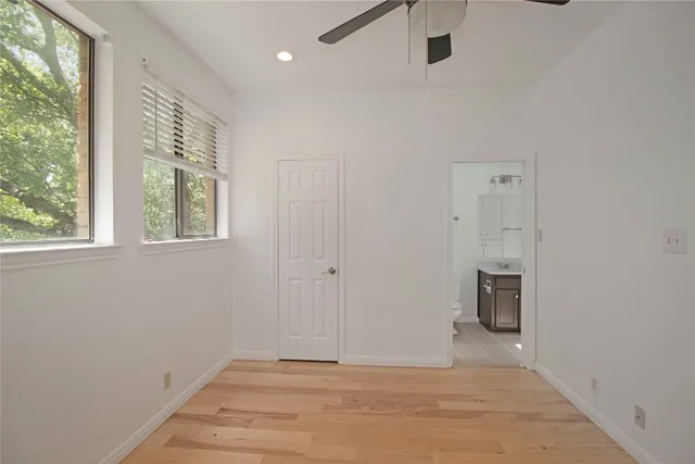 a view of an empty room with a window and a ceiling fan