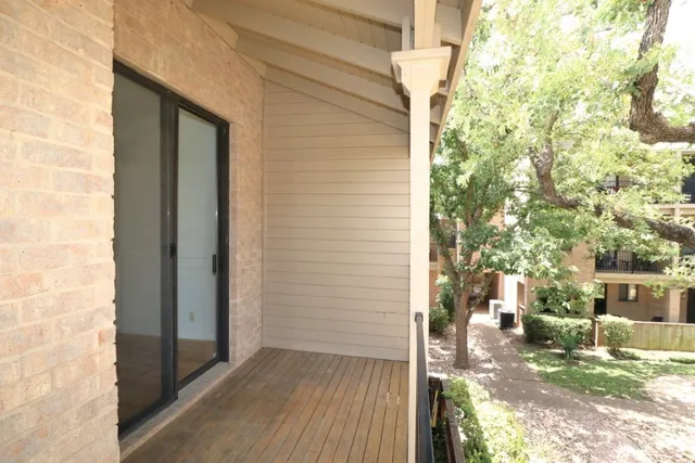a view of a porch with wooden floor and a yard