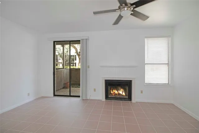 a view of an empty room with a fireplace and a window