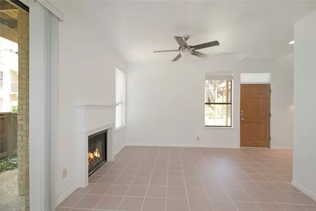 a view of an empty room with a window and fireplace