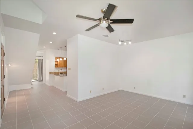 a view of a room with a stylish ceiling fan and entryway