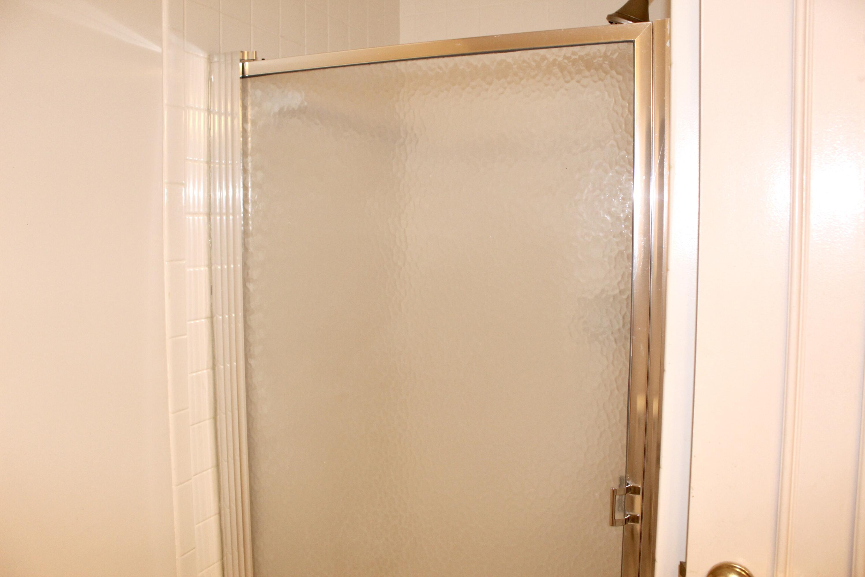 5130 Nesting Way, Unit C Delray Beach, FL 33484 - Photo 13 of 33 a bathroom with a glass shower door