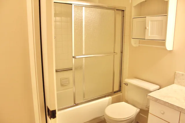 a white toilet sitting next to a bathroom sink