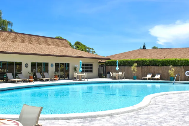 a view of a swimming pool with a table and chairs under an umbrella