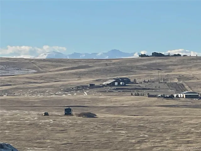 a view of water heater and a room with wooden floor