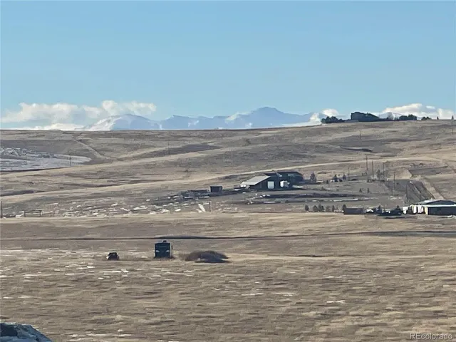 a view of water heater and a room with wooden floor