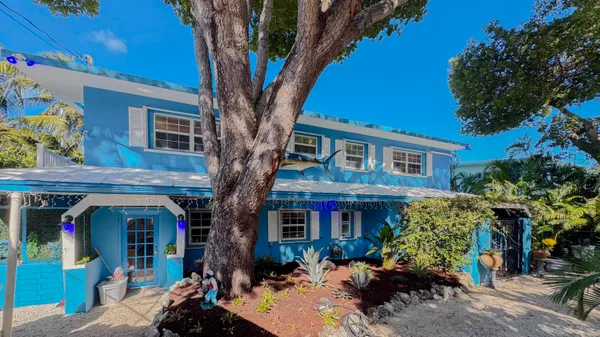 a front view of a house with a tree