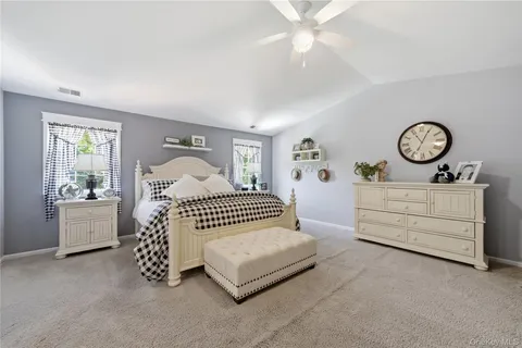a bedroom with a bed a chandelier and dresser