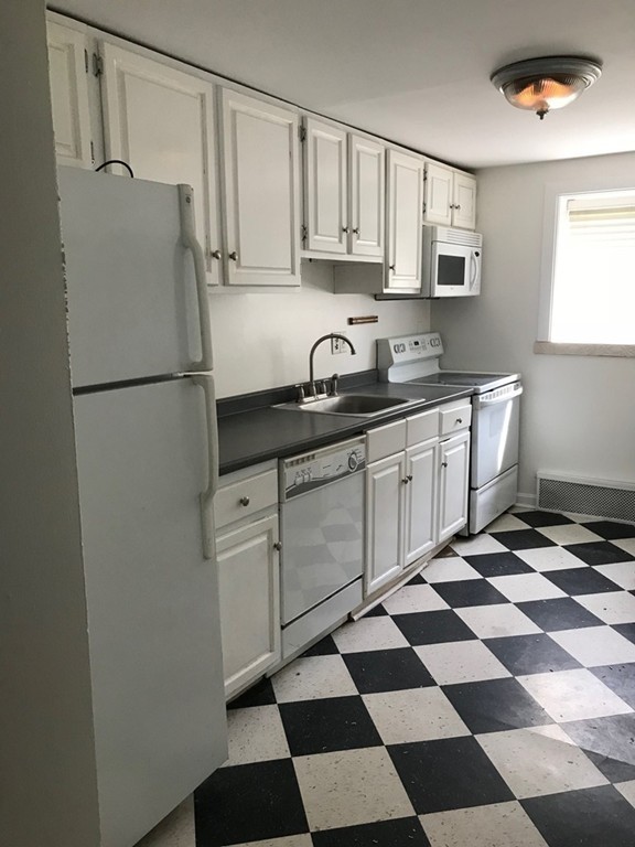 36 Bryon Road, Unit 1 Boston, MA 02467 - Photo 6 of 10 a kitchen with stainless steel appliances a refrigerator sink and cabinets