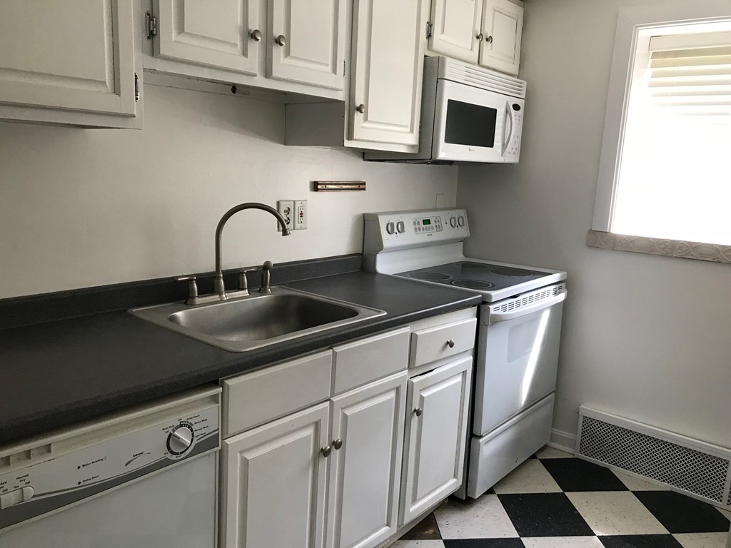 36 Bryon Road, Unit 1 Boston, MA 02467 - Photo 10 of 10 a kitchen with stainless steel appliances granite countertop a sink a stove and a microwave