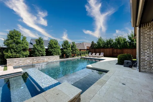 a view of a swimming pool with chairs in patio