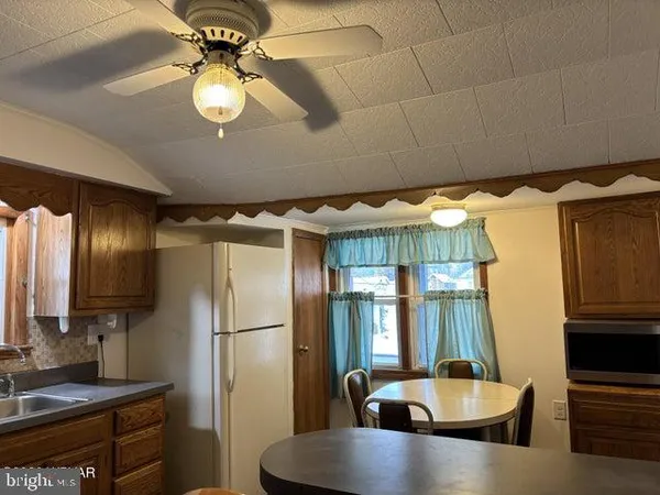 a kitchen with stainless steel appliances granite countertop a sink a refrigerator and a granite counter tops