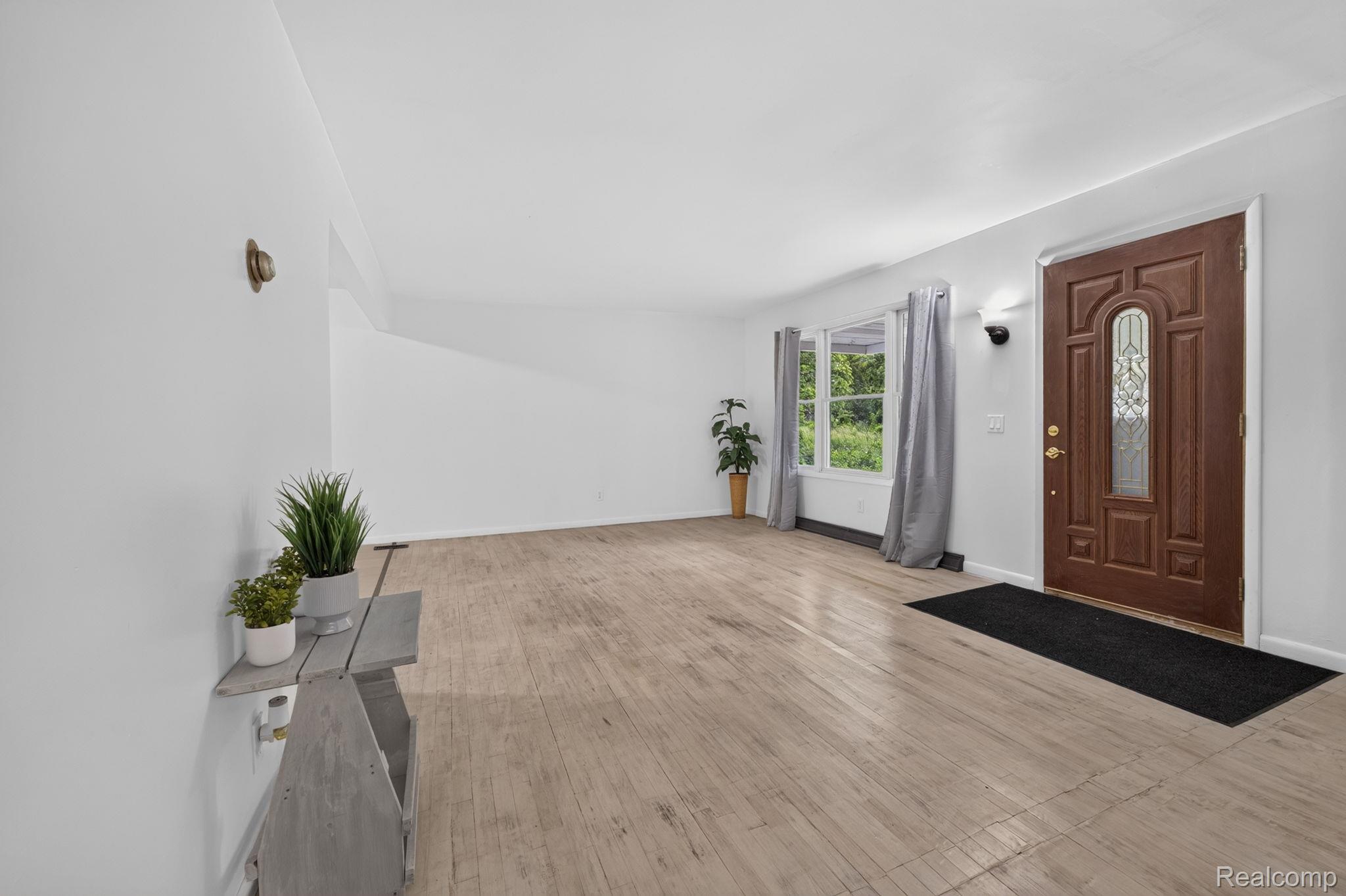 9288 Hilda Lane Flushing, MI 48433 - Photo 11 of 50 Spacious entry area featuring light wood-finish flooring, a paneled front door with decorative glass, and a large bay window