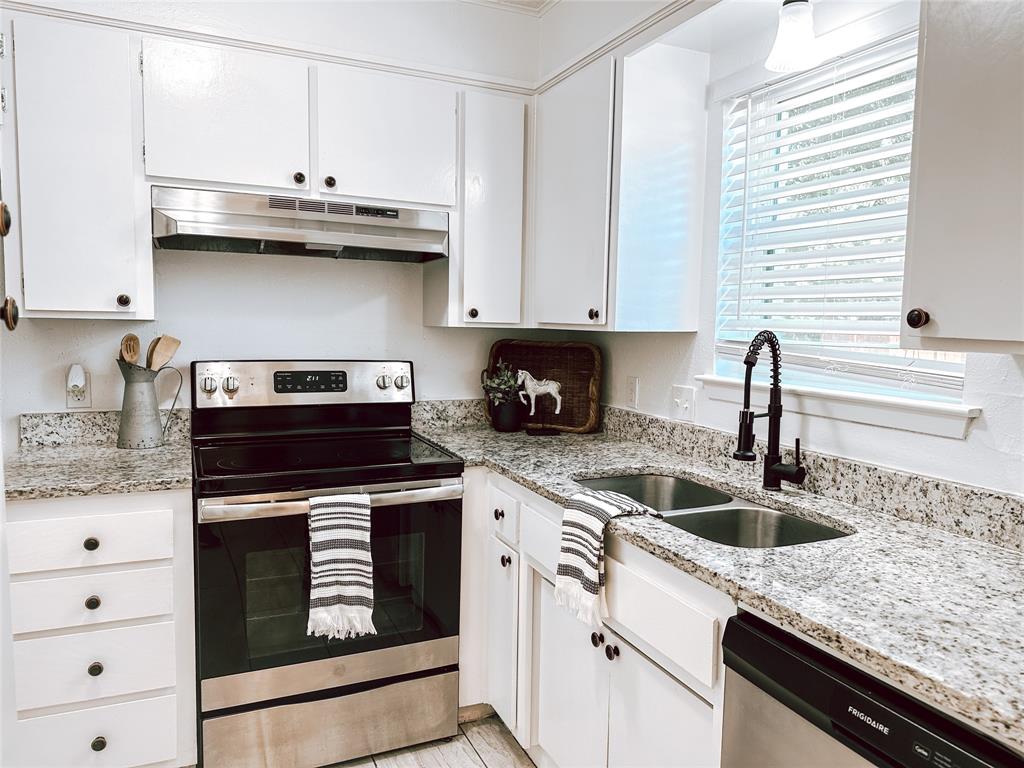 a kitchen with stainless steel appliances granite countertop white cabinets and a stove a oven with white countertops