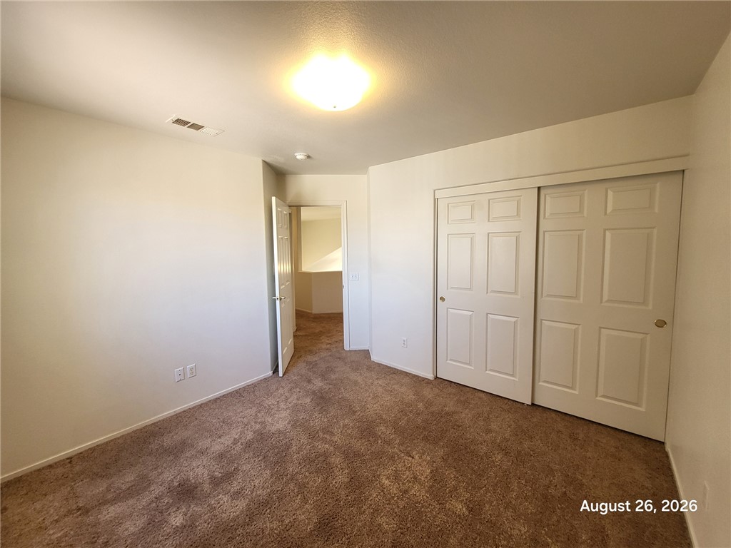 994 Broken Reed Court Henderson, NV 89015 - Photo 10 of 18 Plush carpeting and a large sliding closet door define this comfortable bedroom space.