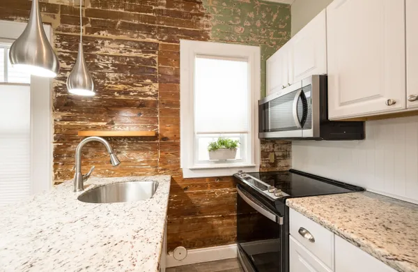 a kitchen with granite countertop a sink a stove top oven microwave and granite counter tops