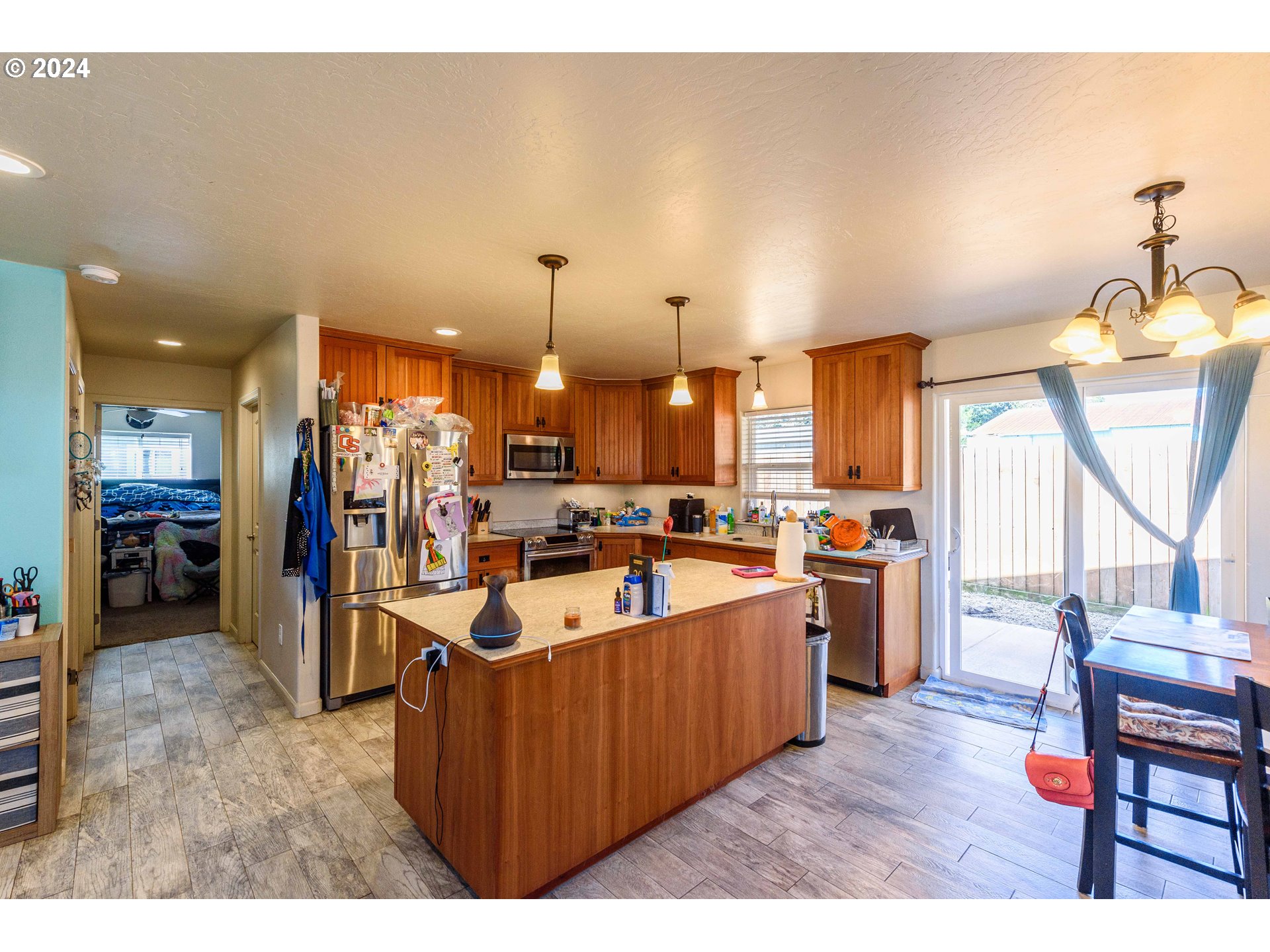 63464 James Drive Coos Bay, OR 97420 - Photo 6 of 25 a large living room with stainless steel appliances kitchen island granite countertop a large kitchen island a stove a refrigerator and a view of living room