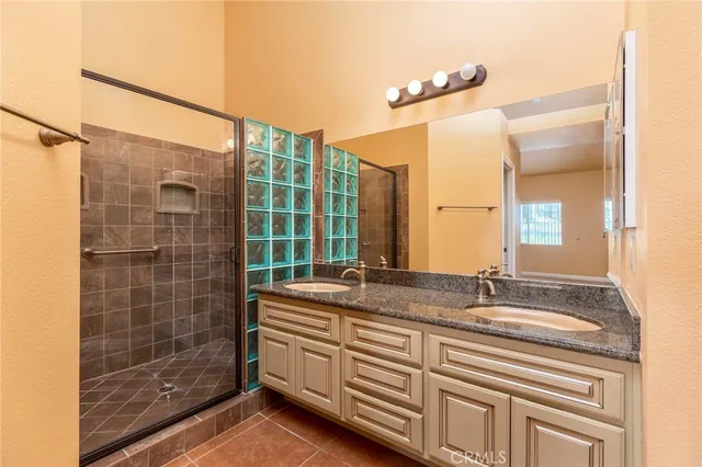 a bathroom with a double vanity sink mirror and shower