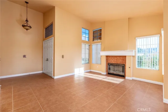 a view of an empty room with a fireplace and a window