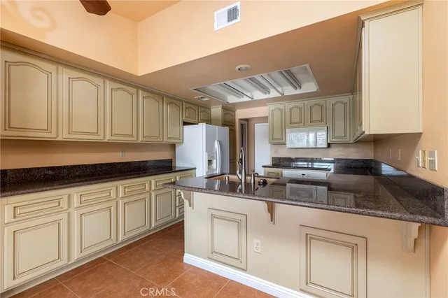 a kitchen with white cabinets and sink