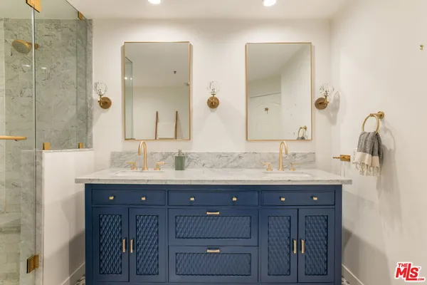 a bathroom with a granite countertop sink vanity and mirror