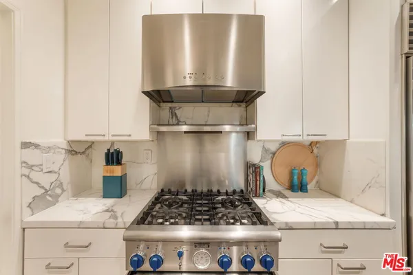 a kitchen with a stove and a white cabinet