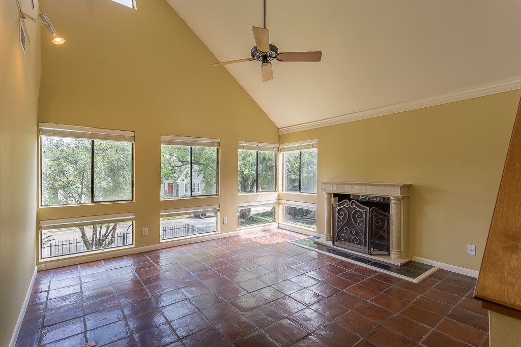 2349 Albans Road, Unit 2 Houston, TX 77005 - Photo 4 of 25 Airy living room bathes in natural light, featuring high ceilings, a classic fireplace, and expansive windows offering serene views.