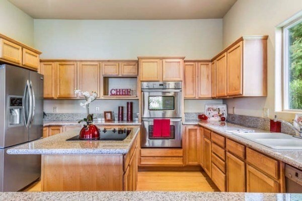 87-410 Kaohe Mauka Road Captain Cook, HI 96704 - Photo 12 of 29 a kitchen with kitchen island granite countertop a sink stove and cabinets