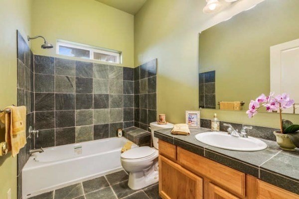 87-410 Kaohe Mauka Road Captain Cook, HI 96704 - Photo 22 of 29 a bathroom with a granite countertop sink toilet a mirror and shower