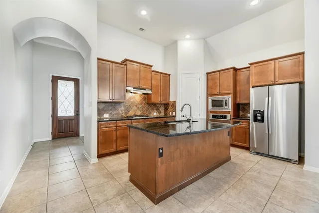 a kitchen with stainless steel appliances granite countertop a refrigerator and a stove