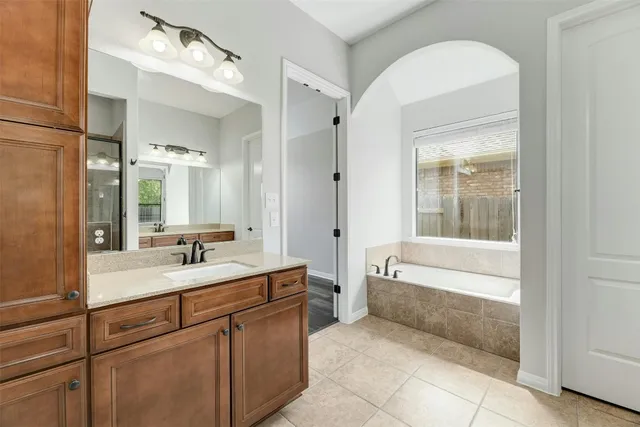a bathroom with a tub sink and mirror