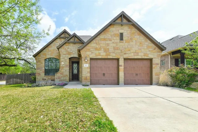 a front view of a house with yard and garage