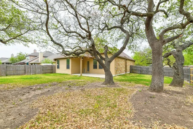 a view of a house with backyard and a tree