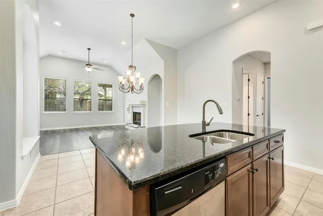 a kitchen with kitchen island a sink and a stove