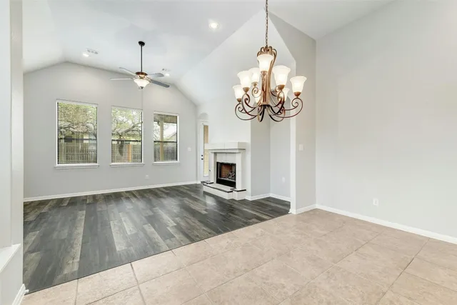 a view of an empty room with a fireplace and a chandelier