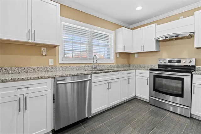 a kitchen with granite countertop cabinets stainless steel appliances and a sink