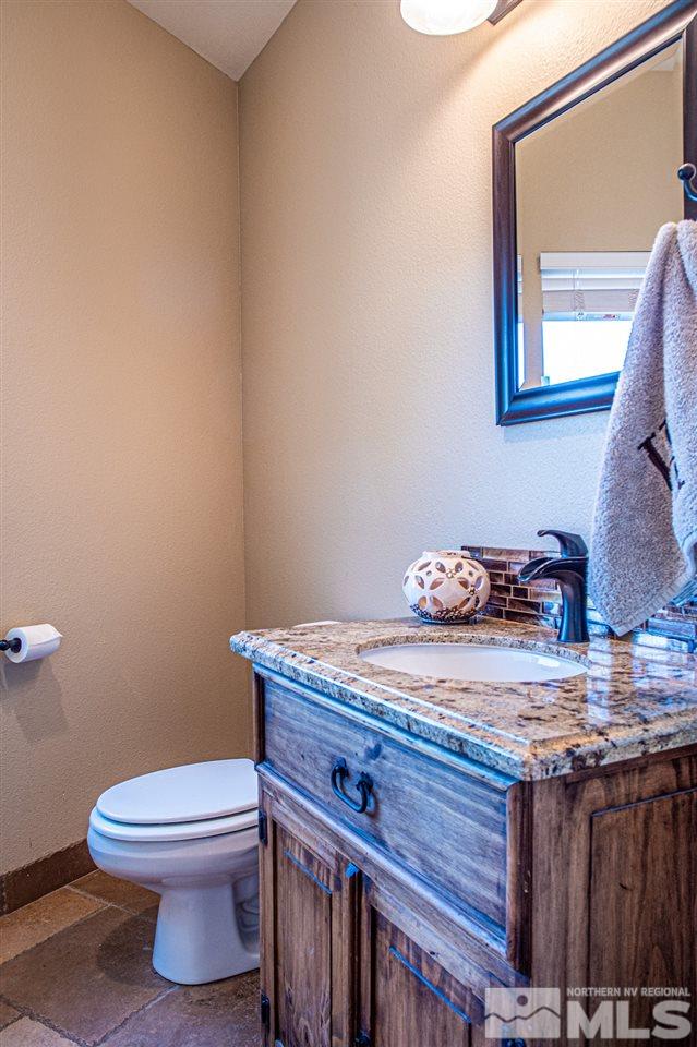 2071 Empire Road Reno, NV 89521 - Photo 9 of 25 a bathroom with a granite countertop toilet and a sink