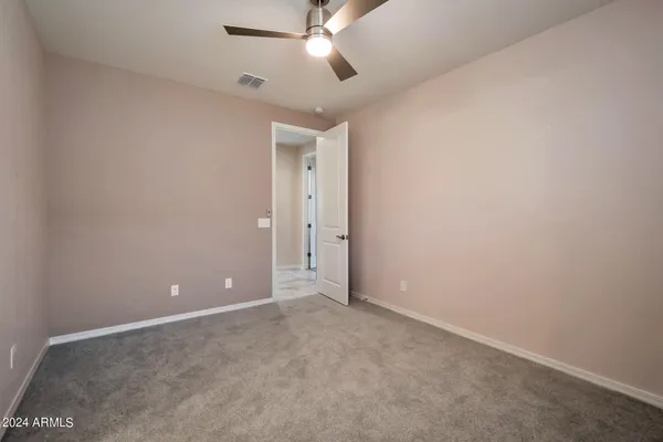 an empty room with closet and a chandelier fan