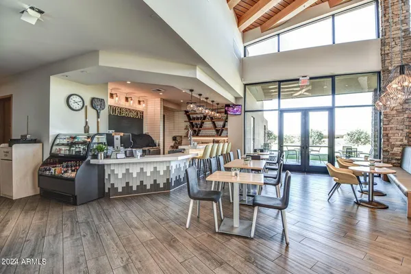 a living room with couches a dining table and kitchen view with wooden floor