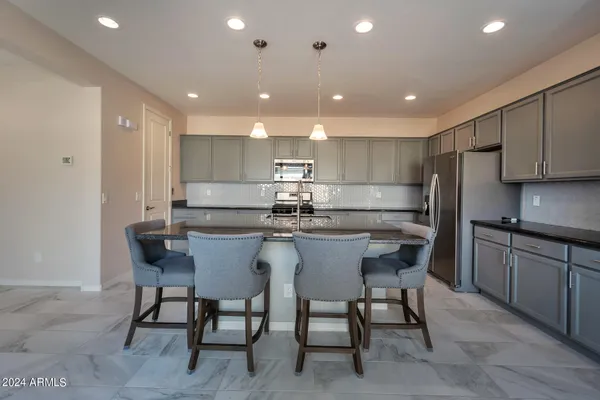 a kitchen with a dining table chairs stainless steel appliances and cabinets