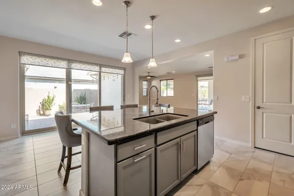 a dining hall with stainless steel appliances granite countertop a granite counter tops a stove a sink and a large window