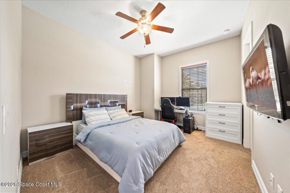 2906 Balting Place Melbourne, FL 32940 - Photo 28 of 44 a bedroom with a bed and a flat screen tv