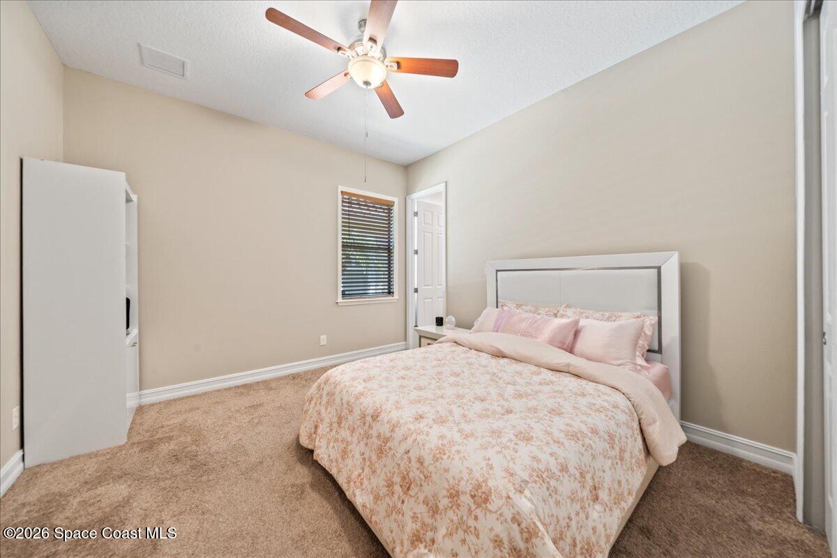 2906 Balting Place Melbourne, FL 32940 - Photo 31 of 44 a bedroom with a large bed and a chandelier