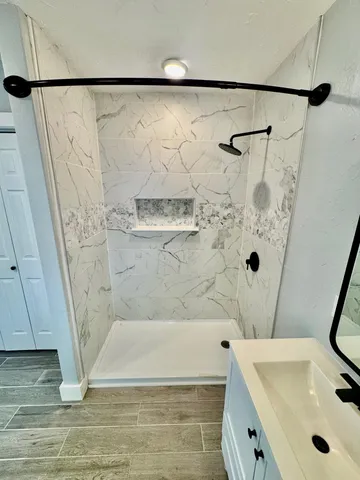 a bathroom with a tub a sink and a shower