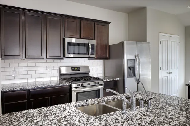 a kitchen with a sink stove and refrigerator
