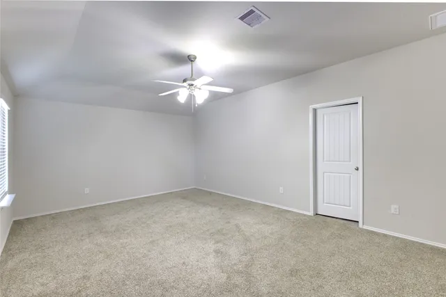 an empty room with a chandelier fan