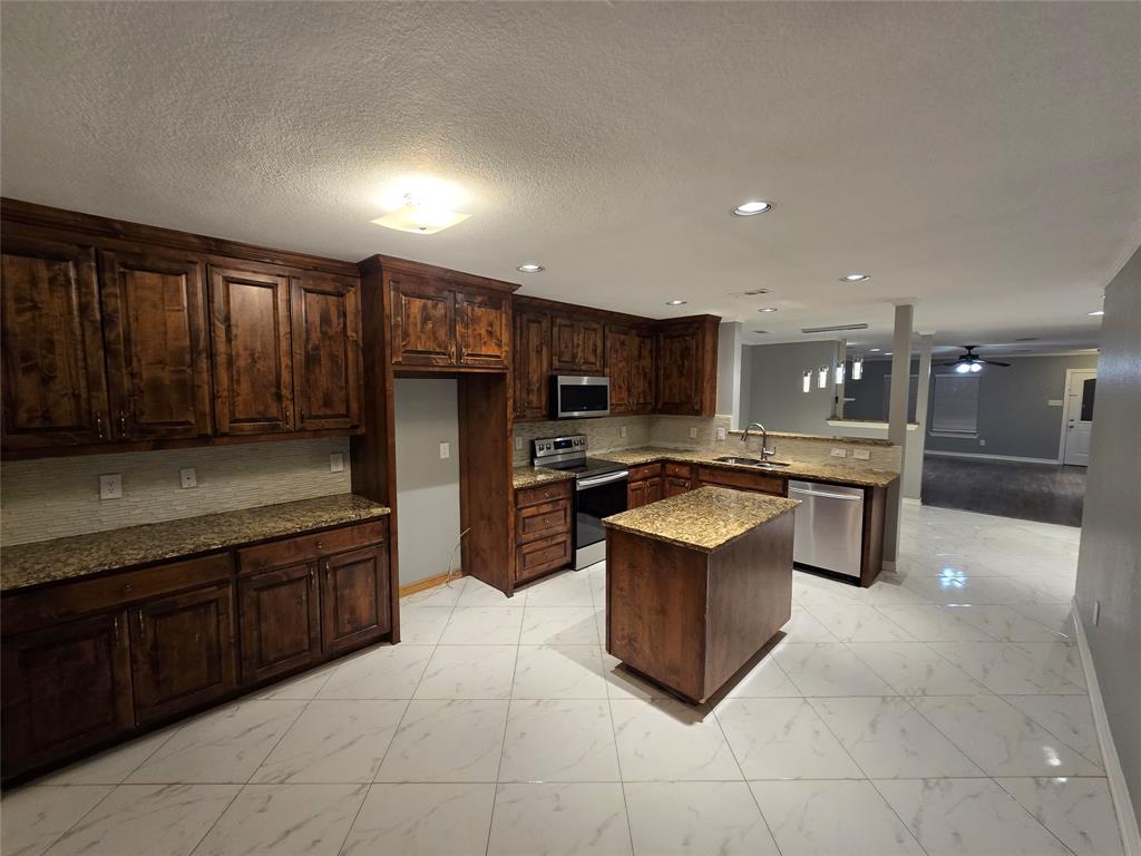 700 White Fields Way Arlington, TX 76002 - Photo 3 of 31 a kitchen with stainless steel appliances granite countertop a stove refrigerator and cabinets