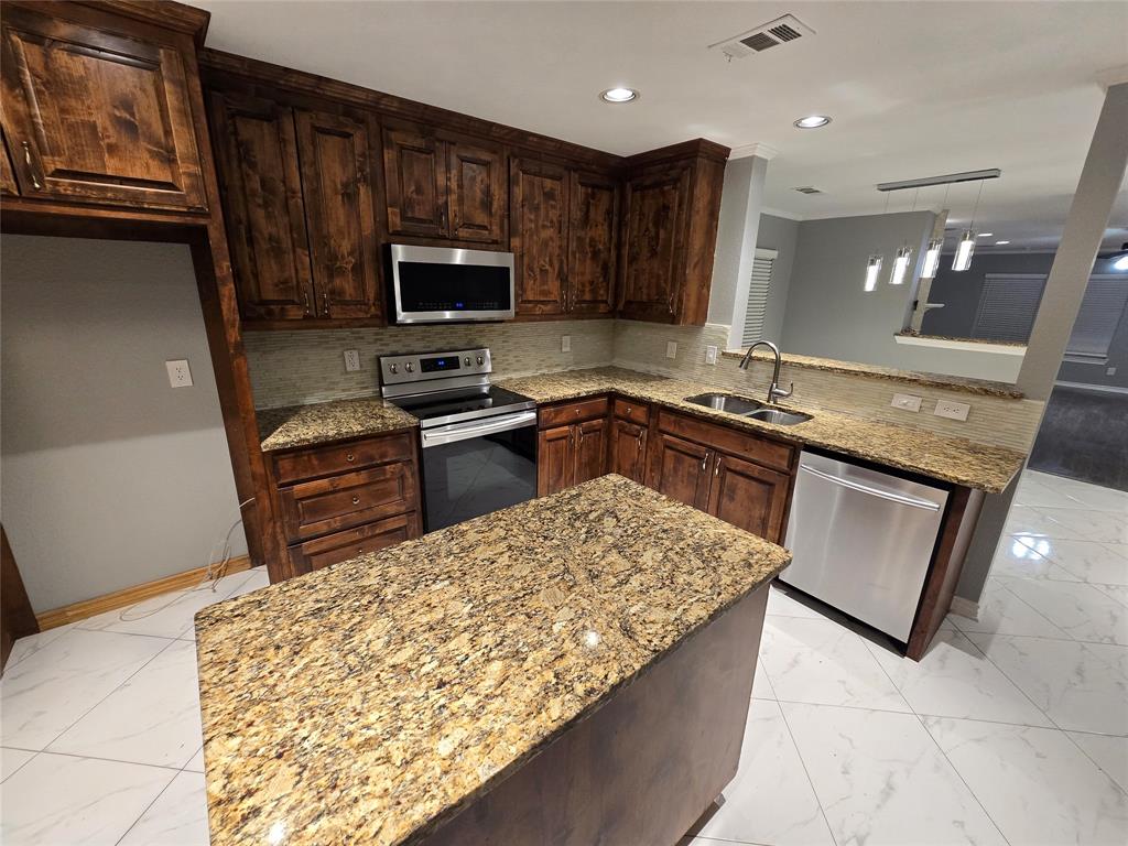 700 White Fields Way Arlington, TX 76002 - Photo 4 of 31 a kitchen with stainless steel appliances granite countertop a sink stove and refrigerator