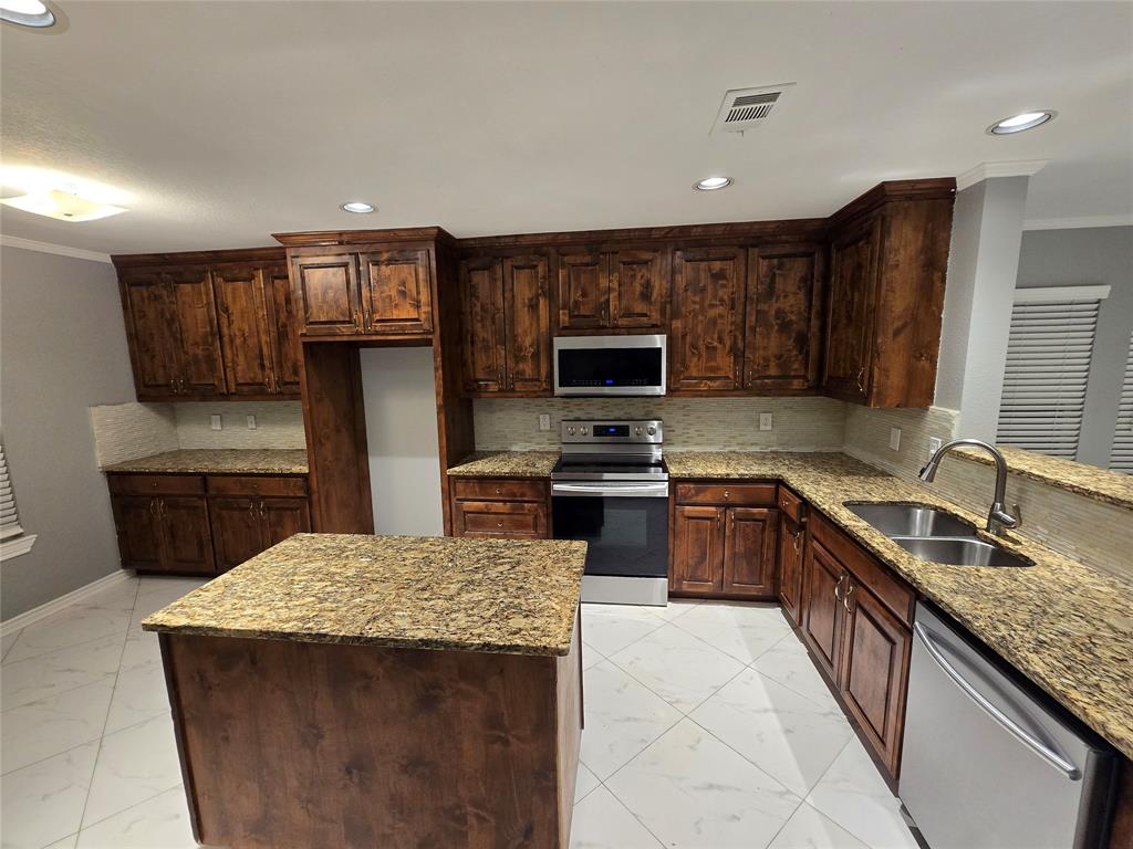 700 White Fields Way Arlington, TX 76002 - Photo 6 of 31 a kitchen with kitchen island granite countertop a sink counter top space appliances and cabinets